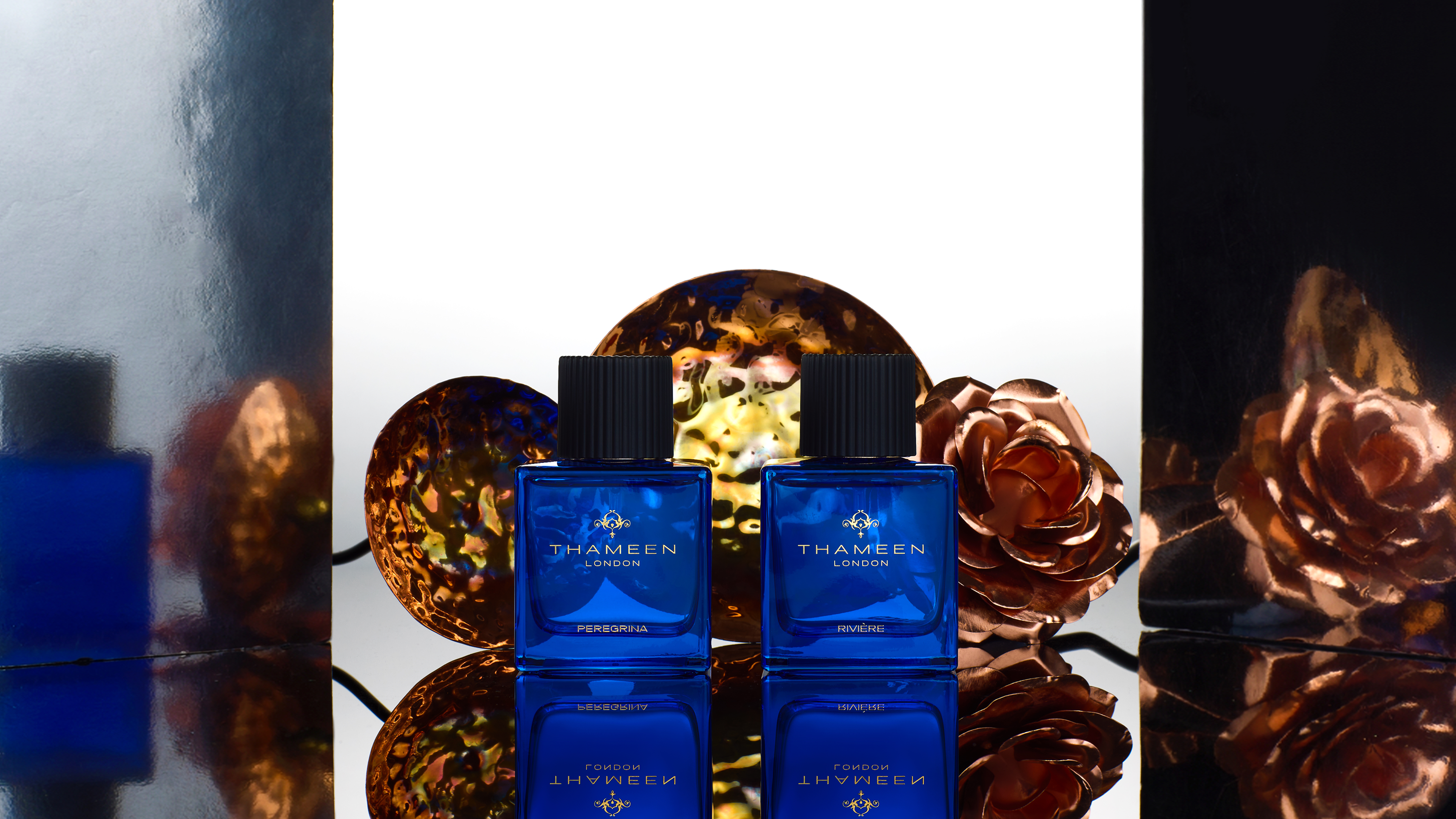 An image of Thameen London's Treasure Collection, featuring 12 blue bottles on a purple and orange gradient background